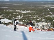 Kaksi laskettelijaa aurinkoisessa rinteessä