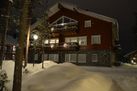 A wooden holiday cottage covered by snow